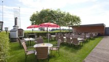 Het terras in de tuin van Hotel Weiss heeft een overdekt gedeelte en beschikt over een haard